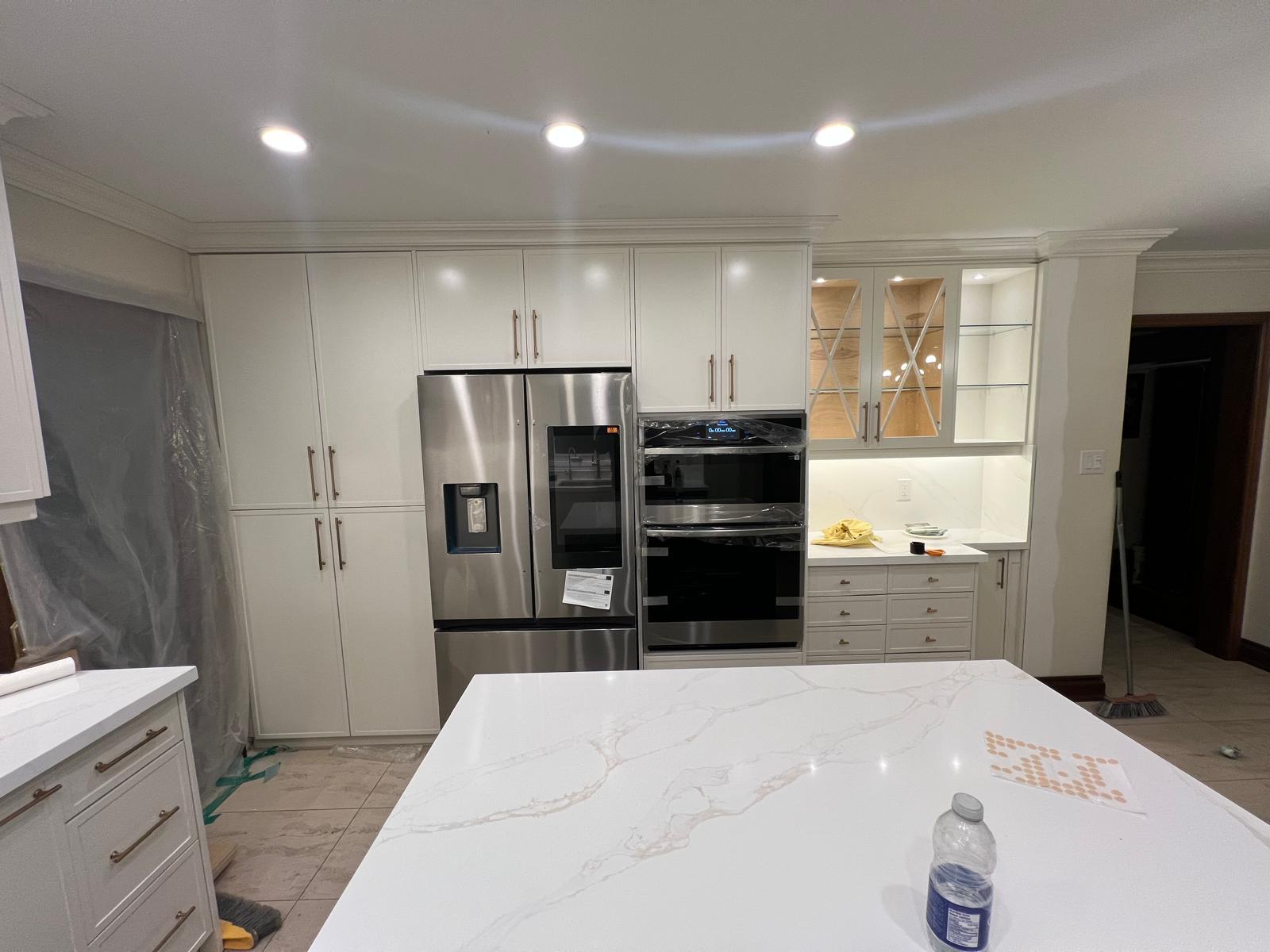 Cream shaker kitchen with brass hardware and glass display cabinets